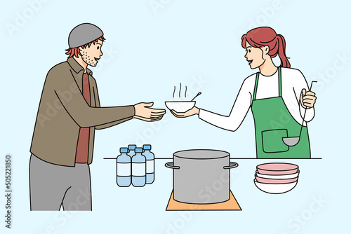 Volunteer serving food to poor homeless people 