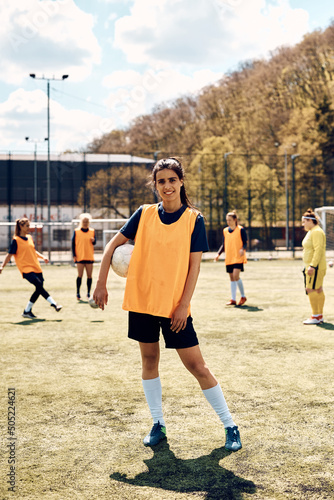 Full length of female soccer player with ball on playing field. © Drazen