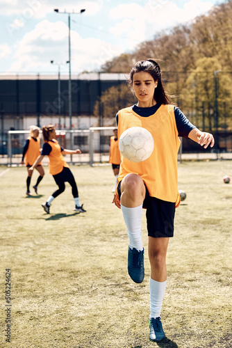 Female soccer player practicing with ball during sports training on stadium. © Drazen