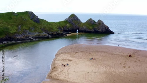 Aerial drone view flying around three cliffs at high tide. Three Cliffs Bay, Gower, Wales photo