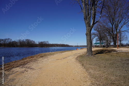 Fototapeta Naklejka Na Ścianę i Meble -  Dirt walking path along a lake during early spring.