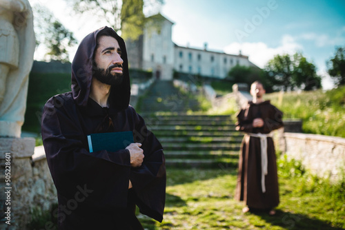 Two monks outside the monastery pray. photo