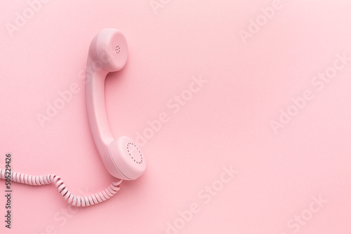 фотографія Pink telephone receiver on pink background