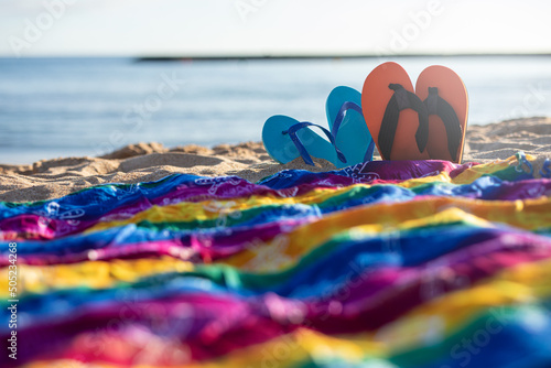 Flip-flops and colorful sarongs on the sand of a sunny beach