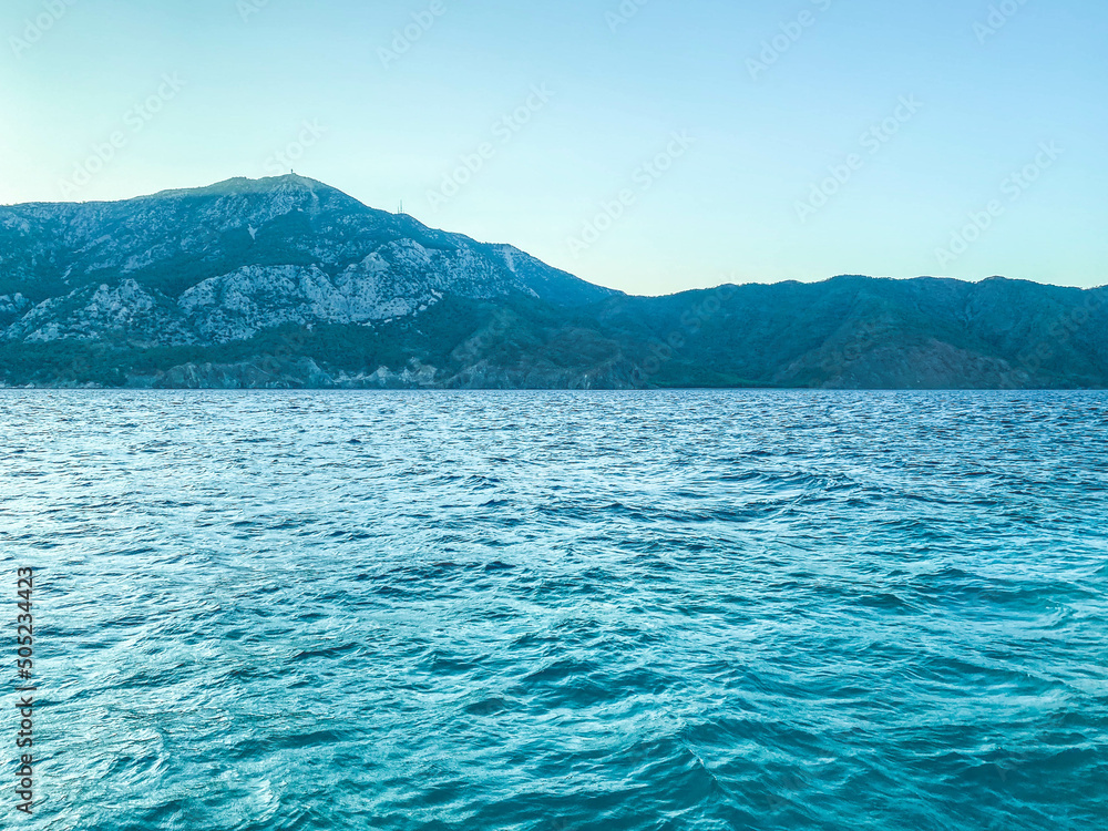 Coast. beauty of the sea, holidays in hot countries. next to the sea are high mountains in greenery and shrubs. blue waves of the sea