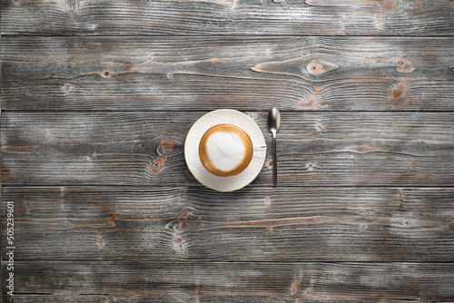 White cup with cappuccino, flat lay. Cappuccino on a wooden background.