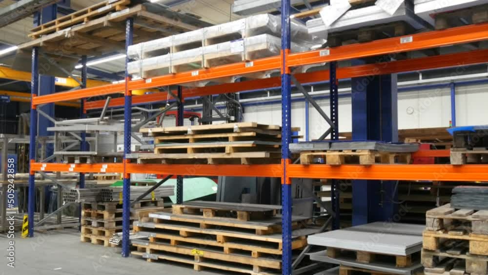 An empty deserted hall of an industrial hall for metal processing. Industrial manufacturing concept, around pallets with products, shelves and tools. Metalworking, industrial, equipment, technology An empty deserted hall of an industrial hall for metal processing. Industrial manufacturing concept, around pallets with products, shelves and tools. Metalworking, industrial, equipment, technology