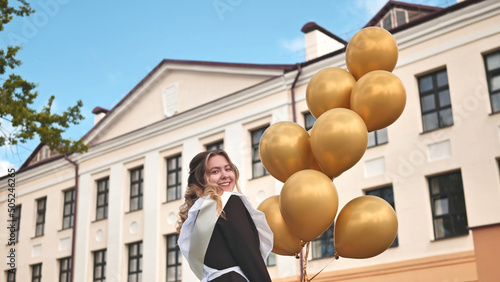 Happy Russian schoolgirl on the last day of school with balloons.