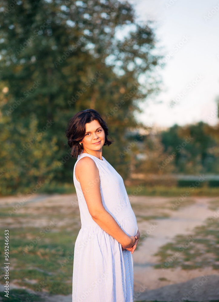 Portrait of happy woman in park at sunset with warm backlight in the background Portrait of happy woman in park at sunset with warm backlight in the background