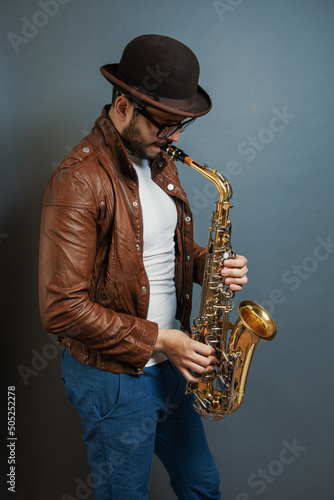 saxophonist male musician in a hat playing, saxophone player