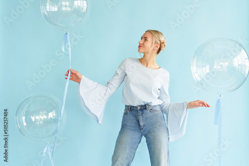 young blonde woman posing in studio with transparent balloons. Concept dreaming © Ксения Левашова