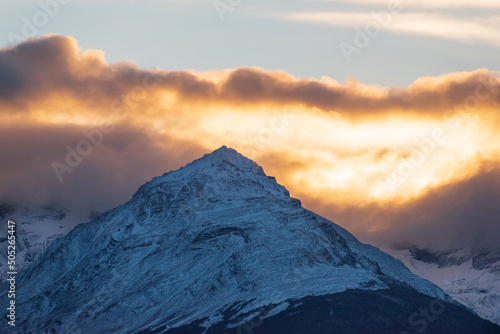 cima de montana nevada con nubes de atardecer, ocaso entre montañas  photo
