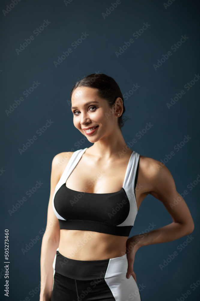 Portrait of a beautiful smiling fitness woman in black and white sportswear
