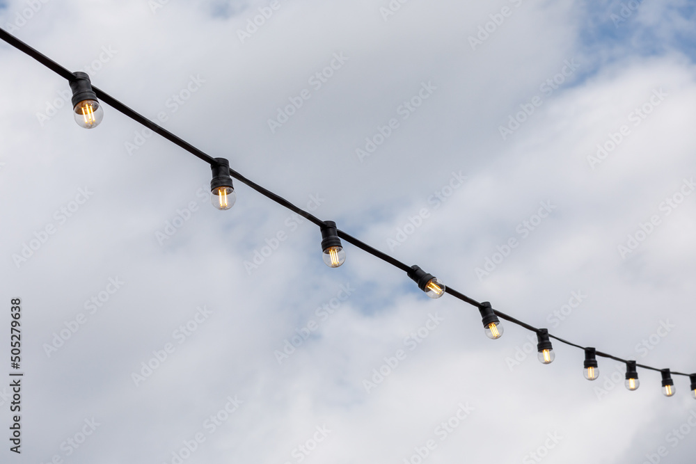 light bulbs garlands on a background of blue sky light bulbs garlands on a background of blue sky