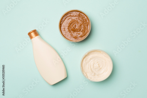 Natural scrub, body cream, shower gel on color background, top view