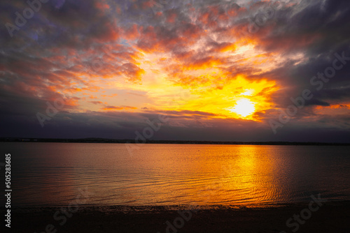 Dramatic cloudscape at the moon rising night at the beach in Noank in Connecticut. Blazing vibrant clouds in the sky at night. photo