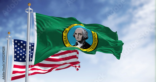 The Washington state flag waving along with the national flag of the United States of America photo