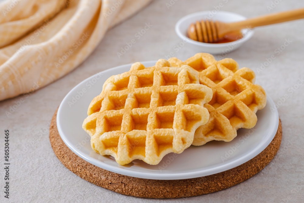 Waffles on white plate and honey in bowl Waffles on white plate and honey in bowl