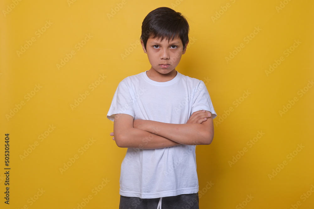 Asian boy in a casual style feeling annoyed and showing sad expression on yellow background. Asian boy in a casual style feeling annoyed and showing sad expression on yellow background.