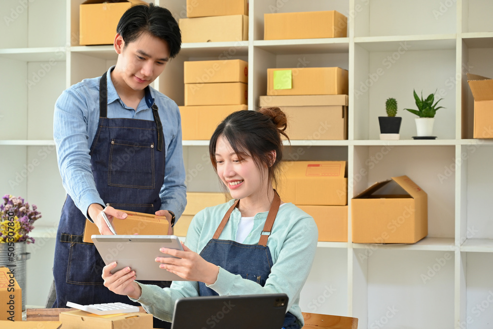 Male boss training his new staff to check product stocks on tablet in the storage room. Male boss training his new staff to check product stocks on tablet in the storage room.