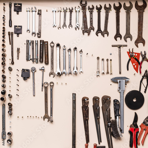 Tool storage and garage organization. Organizers for garage tools. Tools hanging on the wall in the workshop, Tool shelf against the wall