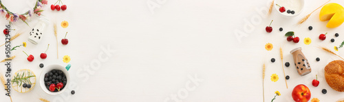 top view photo of dairy products over white wooden background. Symbols of jewish holiday - Shavuot