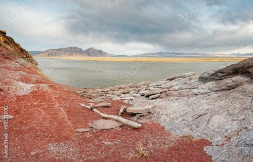 The shore of the Krasnoyarsk reservoir without water, red stones, clay and driftwood on the shore, rainy sky over Mount Tepsey Tepsey photo