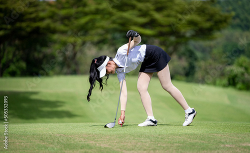 Professional woman golfer teeing golf in golf tournament competition at golf course for winner