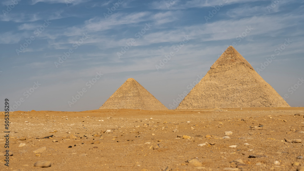 Φωτογραφία Two great pyramids: Cheops and Chephren rise on the Giza plateau against a background of blue sky and clouds
