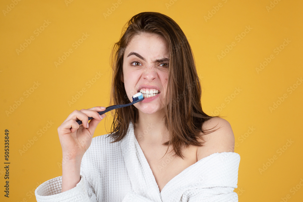 Young woman brushing teeth. Happy funny girl brush her teeth on isolated background. Beautiful wide smile of young woman with great healthy white teeth. Young woman brushing teeth. Happy funny girl brush her teeth on isolated background. Beautiful wide smile of young woman with great healthy white teeth.