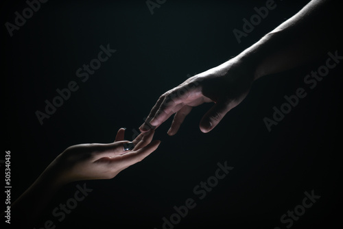 Two hands at the moment of farewell. Romantic touch with fingers, love. Help friend through a tough time. Rescue gesture, support, friendship and salvation concept. Man and woman holding hands.