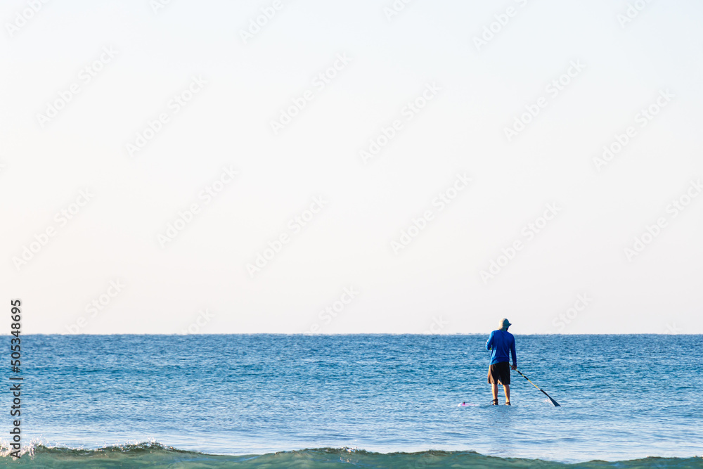 Man surfing the ocean wave on a paddle board