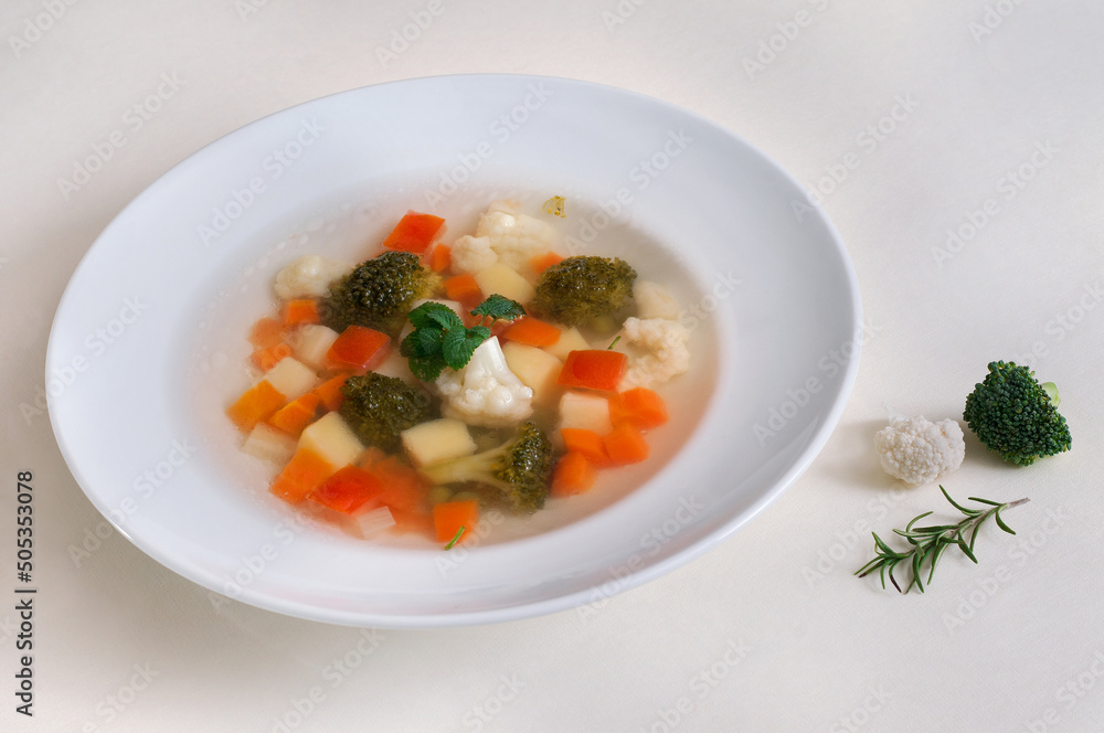 Dietary vegetable soup with a broccoli and cauliflower in a plate on a white background Dietary vegetable soup with a broccoli and cauliflower in a plate on a white background