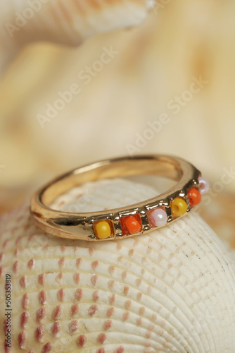 Ring product shot. Golden ring on marine shell background. Jewelry fashion photography.