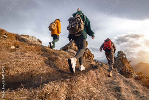 Tableau sur toile Young hikers with small backpacks walks in mountains