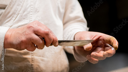 Swordsmith is checking sharpness of blade of small katana