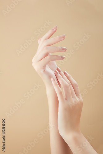 A front view of hand posing in beige background for cosmetic advertising