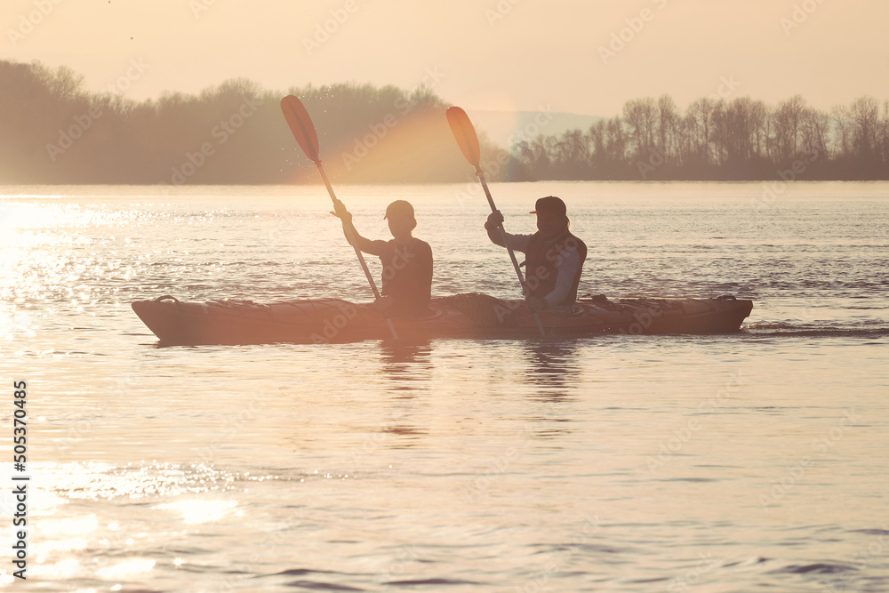 Two active women, best friends kayaking in tandem kayak at Danube river. Kayaking, travel, leisure concept