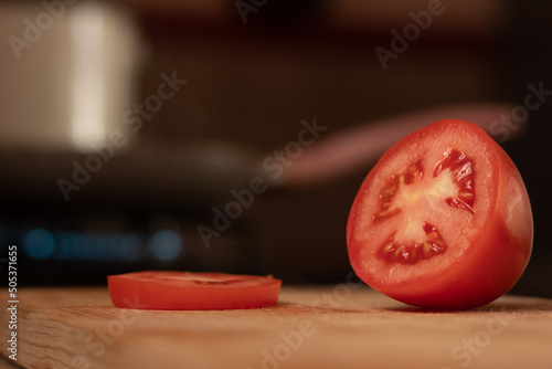 Fototapeta delicious and fresh cut red tomato in close-up focus