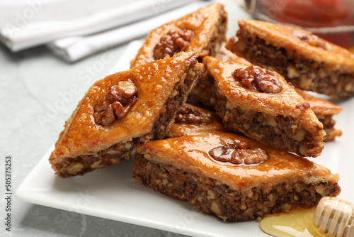 Delicious baklava with walnuts on light grey marble table  closeup