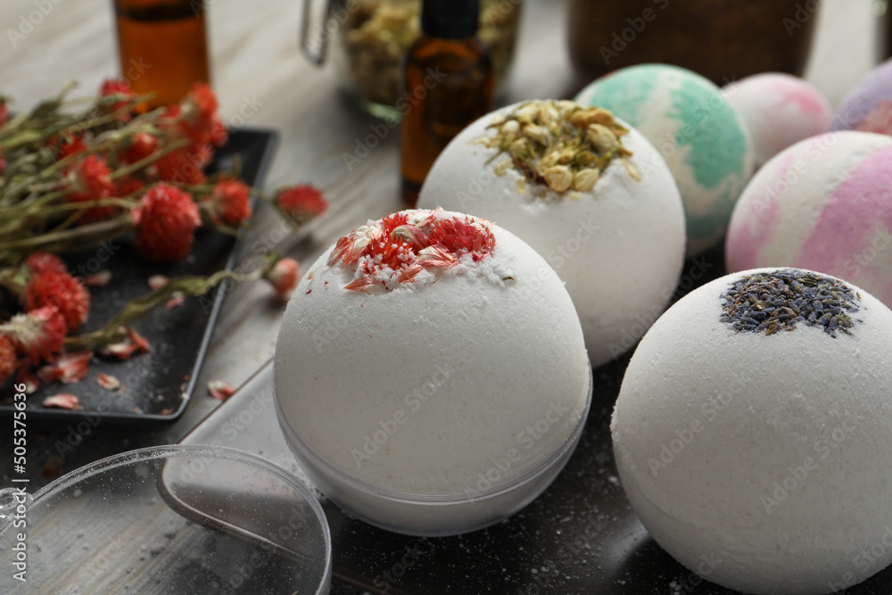 Plate with different bath bombs on wooden table, closeup Plate with different bath bombs on wooden table, closeup