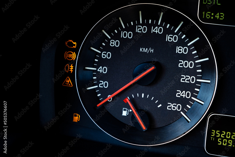 Close-up Instrument car panel with speedometer, low fuel level, ABS and other icons. Engine start and stop. Fuel crisis concept. High price for a diesel, gasoline, oil and natural resources. Red lit Close-up Instrument car panel with speedometer, low fuel level, ABS and other icons. Engine start and stop. Fuel crisis concept. High price for a diesel, gasoline, oil and natural resources. Red lit