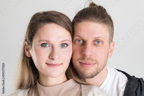 Young caucasian couple of lovers close-up portrait on white background.