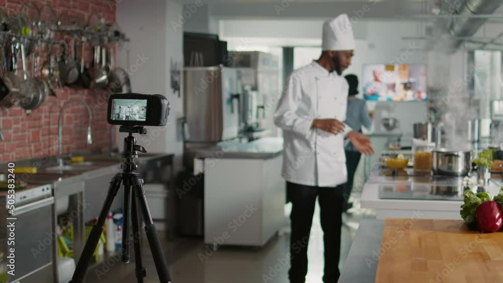 Male chef recording cooking show television vlog on camera, talking about gastronomy and culinary recipe. Young cook filming professional cuisine content for online TV program. Tripod shot. Male chef recording cooking show television vlog on camera, talking about gastronomy and culinary recipe. Young cook filming professional cuisine content for online TV program. Tripod shot.