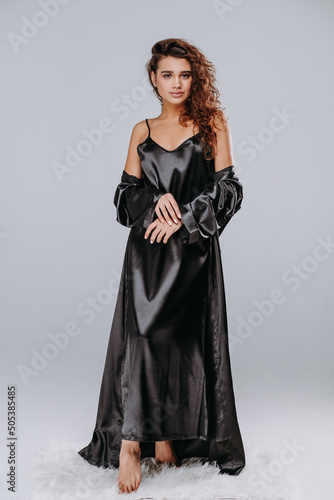 girl in a black robe, pajama on a gray background. home clothes concept. catalog photo