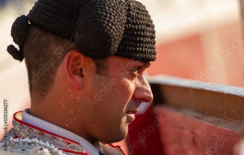 close up of a concentrated bullfighter watches the bullfight from the sidelines