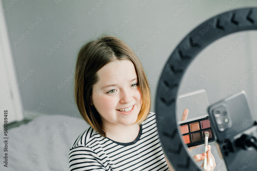 Caucasian teenager girl blogger recording a tutorial video for her beauty blog using smartphone at home. Caucasian teenager girl blogger recording a tutorial video for her beauty blog using smartphone at home.
