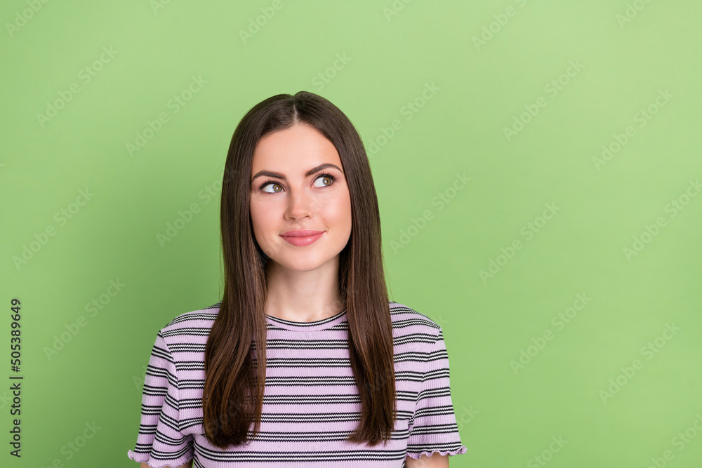 Fototapeta premium Portrait of attractive minded cheery brown-haired girl thinking copy space isolated over bright green color background