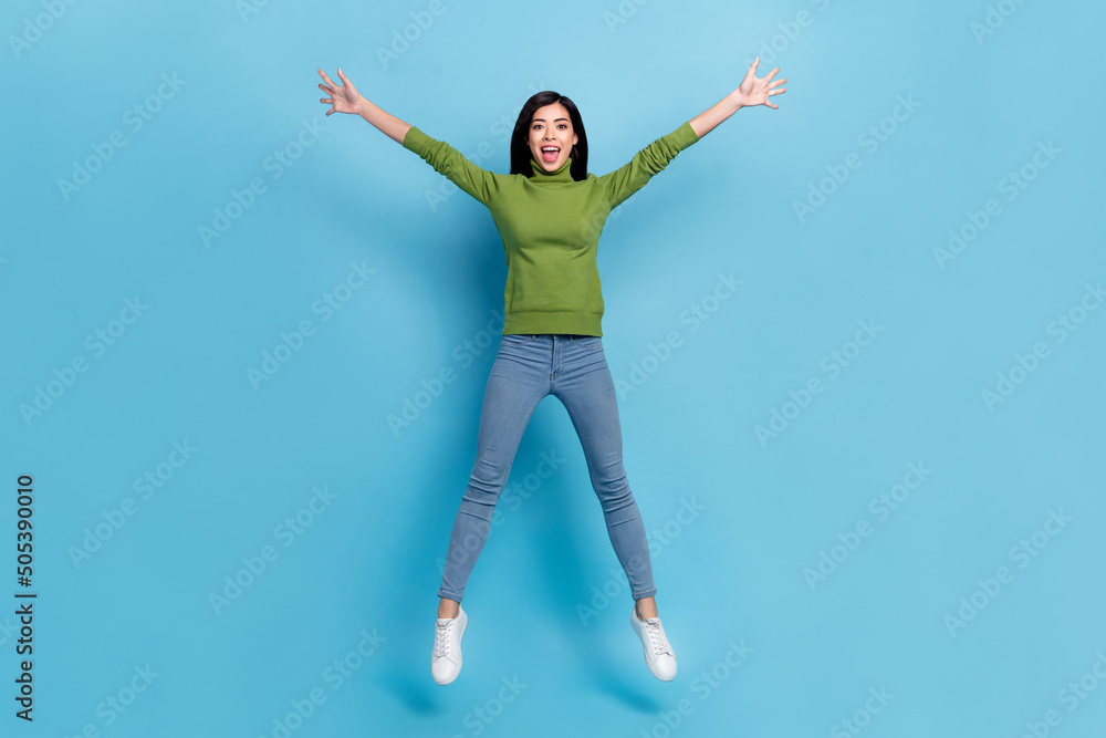 Full length photo of cool millennial brunette lady jump yell wear jumper jeans footwear isolated on blue background Full length photo of cool millennial brunette lady jump yell wear jumper jeans footwear isolated on blue background