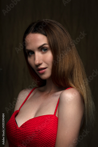 portrait of a beautiful young woman in a red dress, studio shot on a dark background